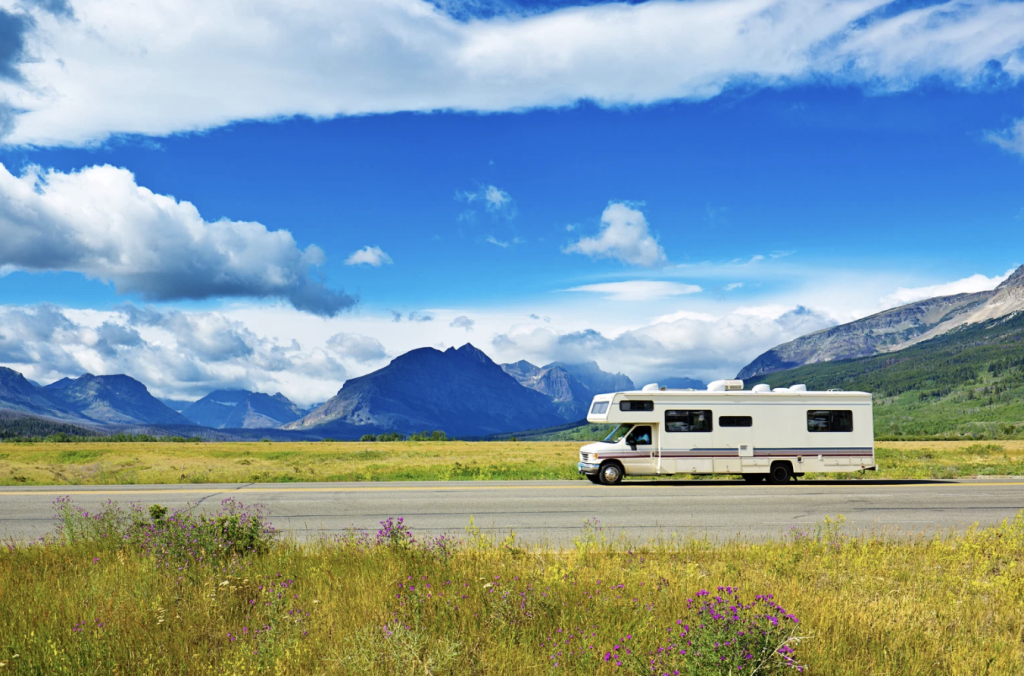 rv driving down the road near glacier mountain